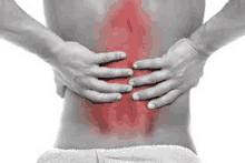 a man is holding his back in pain with red spots on it .