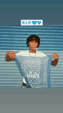 a man holding a blue bandana that says lil loaded on it