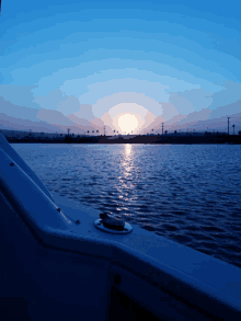 a sunset over a body of water with a few buildings in the distance