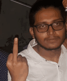 a man wearing glasses and a white shirt giving the middle finger