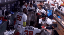 a group of baseball players are standing in a dugout and one of them has the number 38 on his jersey