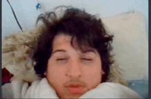 a man with his eyes closed is laying in bed