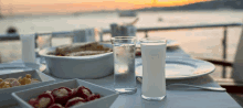 two glasses of water sit on a table next to a plate of food