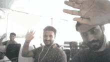 a man with a beard is waving his hand