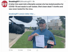 a man is holding a piece of paper in front of a microphone and a sign that says breaking 911