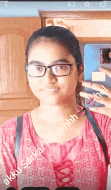 a girl wearing glasses is taking a selfie with the name akku written on the bottom