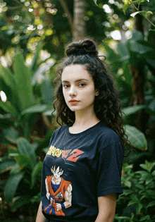 a girl with curly hair wears a black dragon ball z shirt