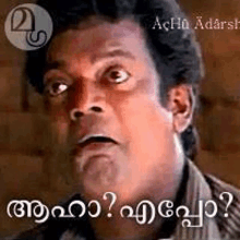 a man in a striped shirt is making a funny face in malayalam .