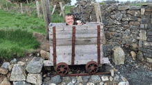 a man is holding a dog in a wooden cart