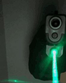 a gun with a green laser beam coming out of it 's barrel