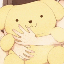 a girl is hugging a yellow teddy bear with her hands .