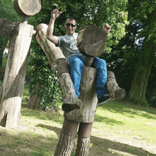 a man is sitting on a tree stump wearing sunglasses and a shirt that says ' california ' on it