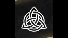 a black and white celtic symbol with a triangle in the middle