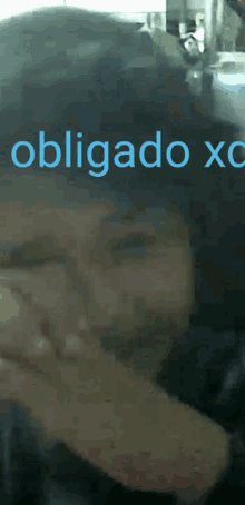 a blurry picture of a person with the words obrigado xc on the bottom right