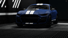 a blue sports car with white stripes is parked in a dark room