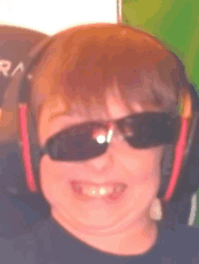 a young boy wearing sunglasses and headphones is smiling .