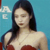 a woman in a red dress is standing in front of a blue background .