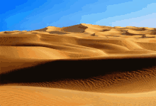 a desert landscape with a blue sky and sand dunes