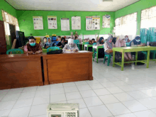 a group of people wearing face masks are sitting at desks in a classroom