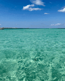 a large body of water with a blue sky and clouds in the background