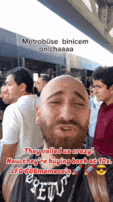 a bald man with a beard is standing in front of a crowd of people and they called us crazy