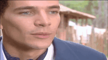 a close up of a man 's face in a blue suit and tie