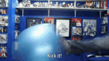 a person kicking a blue ball with the words kick it written on the bottom