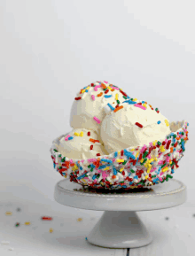 three scoops of ice cream in a bowl with sprinkles on top