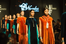 a group of models walk down a runway in front of a sign that says nurdos