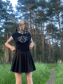 a girl wearing a black athletic shirt and a black skirt