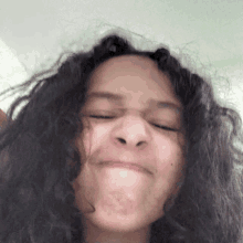 a woman with curly hair makes a funny face