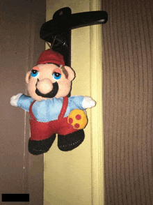 a stuffed mario hanging from a door handle