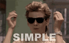 a man wearing sunglasses has the word simple written in white