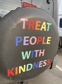 a tire cover says treat people with kindness