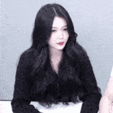 a woman with long black hair is wearing a black shirt