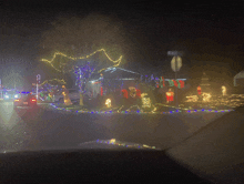 a car is driving past a house with christmas lights