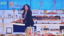 a woman is standing in front of a display of food with the word bread on the wall behind her