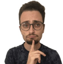 a man with glasses and a beard holds his finger to his mouth