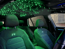 a car with green lights on the ceiling and seats with the letter r on them