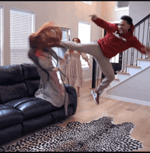 a man in a red sweatshirt is kicking a woman in the air