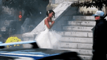 a bride in a wedding dress is walking down stairs