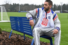 a man is sitting on a bench with a shirt that says 100