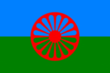 a gypsy flag with a red wheel on a blue and green background