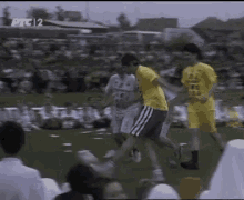 a group of soccer players are playing on a field with a crowd in the background and a sign that says ptc 2