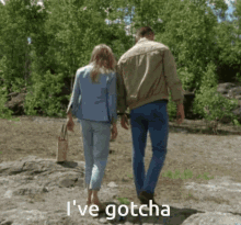 a man and a woman walking in a field with the words " i 've gotcha " written below them