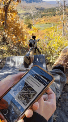 a person is looking at a cell phone that says ' hunting ' on the screen