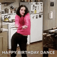 a woman is dancing in a kitchen with the words `` happy birthday dance '' written above her .