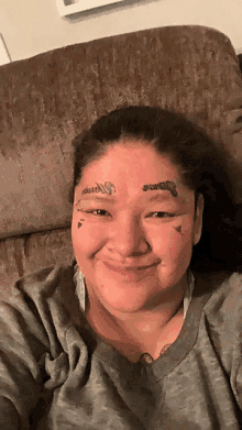 a woman has a tattoo on her forehead that says ' warrior '