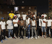 a group of young men are posing for a picture together in front of a building .