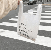 a person is holding a white bag that says bread espresso